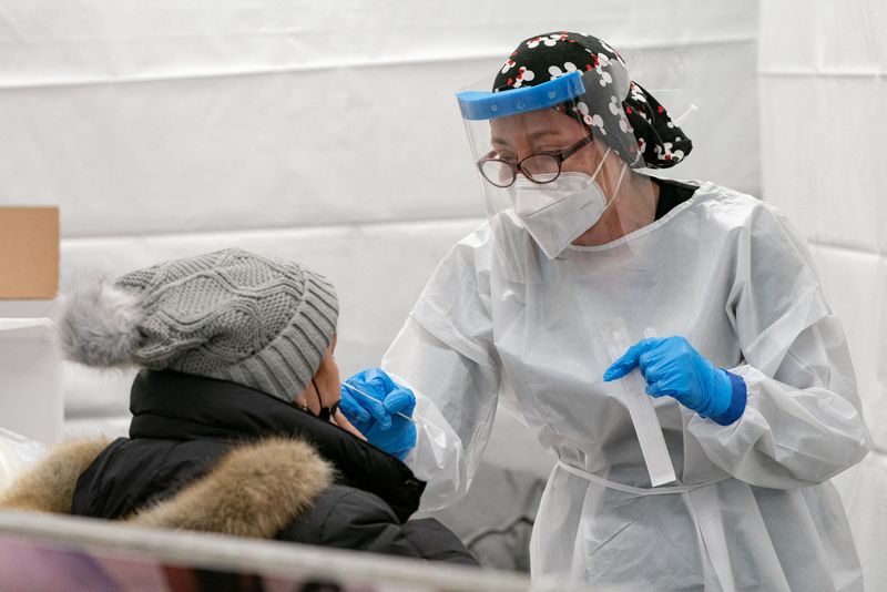 &copy; Reuters. Una donna riceve un tampone nasale in un nuovo punto di test pop-up Covid-19 nella stazione della metropolitana di Times Square a Manhattan, New York City, Stati Uniti, 27 dicembre 2021. REUTERS/Jeenah Moon
