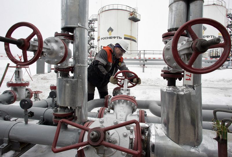 &copy; Reuters. عامل يدير صمام أنبوب لضخ النفط في حقل شرقي إيجيفسك القريبة من جبال الأورال. صورة من أرشيف رويترز.