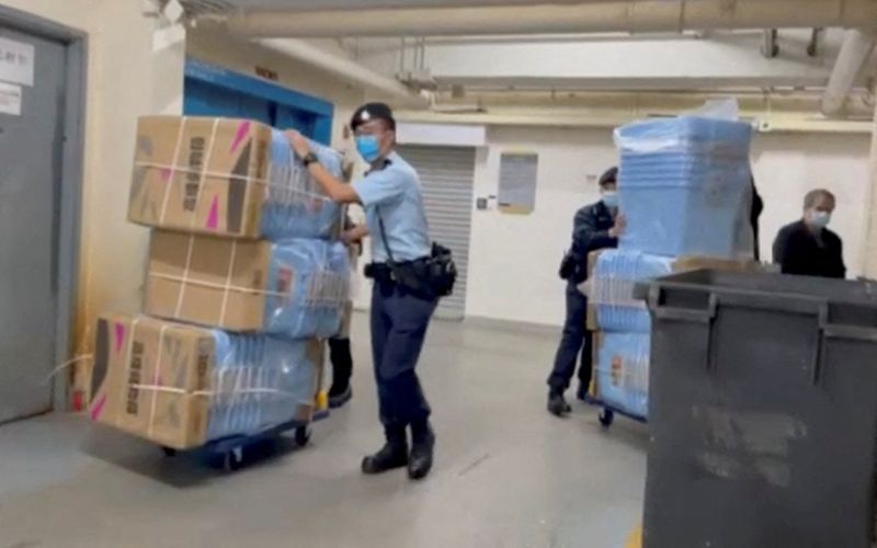 &copy; Reuters. Police officers push boxes to collect evidence during their raid operation at Stand News office, in Hong Kong, China December, 29, 2021 in this still image from a video obtained by Reuters