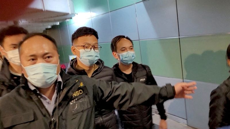 &copy; Reuters. Agentes de policía escoltan al editor de Stand News, Patrick Lam, a través de un pasillo del edificio mientras salen después de que la policía registrara su oficina, en Hongkong, China, 29 de diciembre de 2021, en esta imagen fija obtenida por Reuters