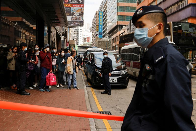 &copy; Reuters. 警察の家宅捜索を受けた香港の民主派ネットメディア、立場新聞（スタンド・ニュース）は２９日、業務を停止すると発表した。捜索されたビル前で警備する警官、２９日撮影。（２０２１