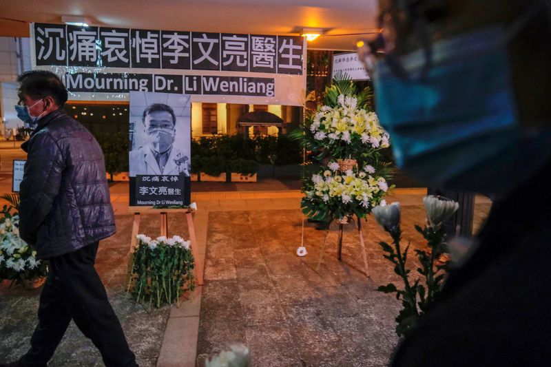 &copy; Reuters. FILE PHOTO: People wearing masks attend a vigil for late Li Wenliang, an ophthalmologist who died of coronavirus at a hospital in Wuhan, in Hong Kong, China February 7, 2020. REUTERS/Tyrone Siu/File Photo