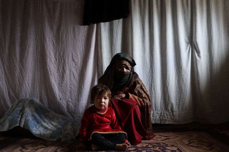 &copy; Reuters. الأرملة الأفغانية كُبرى مع حفيدها في منزلها بباميان يوم 22 ديسمبر كانون الأول 2021. تصوير: علي خارا - رويترز 