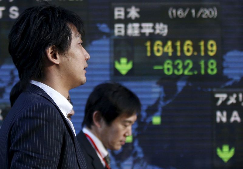 &copy; Reuters. Men walk past an electronic board showing Japan's Nikkei average outside a brokerage in Tokyo, Japan January 20, 2016. Japan's benchmark Nikkei share average tumbled to a fresh 14-1/2 month low on Wednesday as global markets were battered by plunging crud