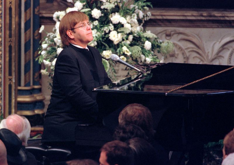 &copy; Reuters. FOTO DE ARCHIVO: El cantante pop Elton John toca una versión especialmente reescrita de su clásico Candle in the Wind durante el funeral de Diana, Princesa de Gales, en la Abadía de Westminster. Millones de personas recorrieron las calles de Londres pa