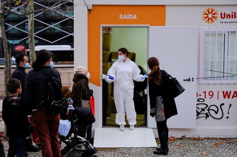 &copy; Reuters. FOTO DE ARCHIVO: Un trabajador de la salud habla con la gente mientras esperan para hacer pruebas para la enfermedad del coronavirus (COVID-19) en el día antes de la víspera de Navidad en Campo Pequeno, Lisboa, Portugal, 23 de diciembre de 2021. REUTERS