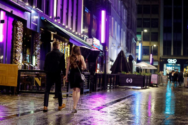 &copy; Reuters. A man and a woman walk along a street, amidst the spread of the coronavirus disease (COVID-19) pandemic, Leeds, Britain, December 30, 2021. REUTERS/Jason Cairnduff