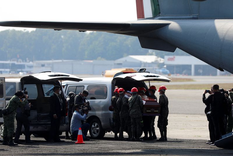 © Reuters. Mexican soldiers upload into a hearse one of 15 coffins of Guatemalan migrants who died in a truck crash in southern Mexico after arriving from Mexico at the Guatemalan Air Force (FAG) headquarters in Guatemala City, Guatemala, December 30, 2021. REUTERS/Sandra Sebastian