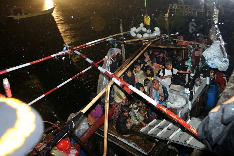 &copy; Reuters. لاجئون من الروهينجا يقفون في زورق عند ميناء قرب بلدة كرنج جوكه في أتشيه بإندونيسيا صباح الجمعة.
(صورة لرويترز من وكالة أنتارا للصور ويتم توز