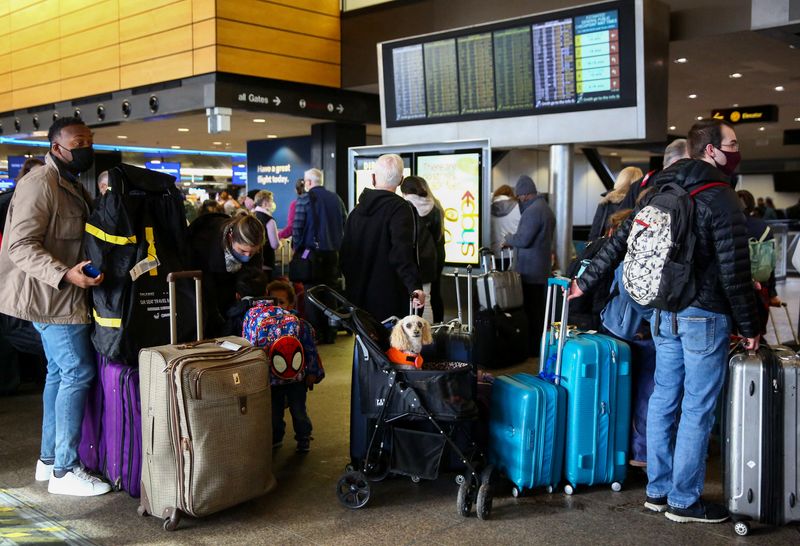 &copy; Reuters. مسافرون ينتظرون ركوب طائرة في مطار تاكوما الدولي في سياتل بالولايات المتحدة يوم 27 ديسمبر كانون الأول 2021. تصوير: لينزي واسون - رويترز.