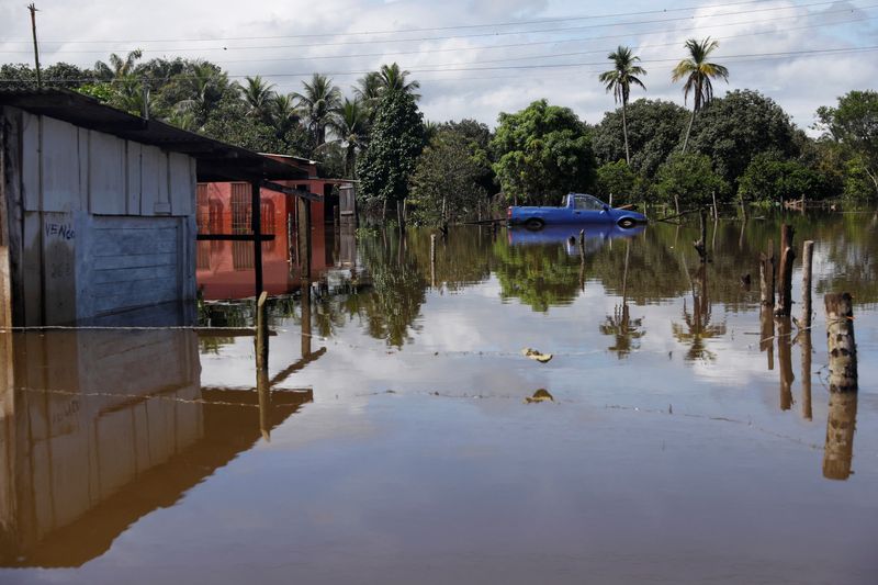&copy; Reuters. FILE PHOTO: Houses and a car are partially submerged in a flooded street, in Ilheus, Bahia state, Brazil December 30, 2021. REUTERS/Amanda Perobelli