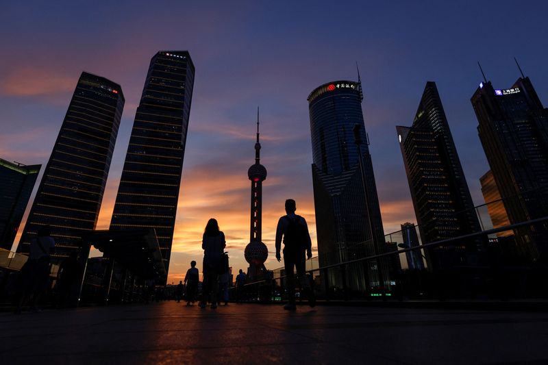 © Reuters. FILE PHOTO: People walk in Lujiazui financial district during sunset in Pudong, Shanghai, China July 13, 2021. REUTERS/Aly Song