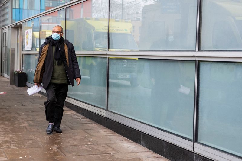&copy; Reuters. A man wearing a face mask, amid the spread of the coronavirus disease (COVID-19), walks past the ambulances at the Royal London Hospital, in London, Britain December 31, 2021. REUTERS/May James