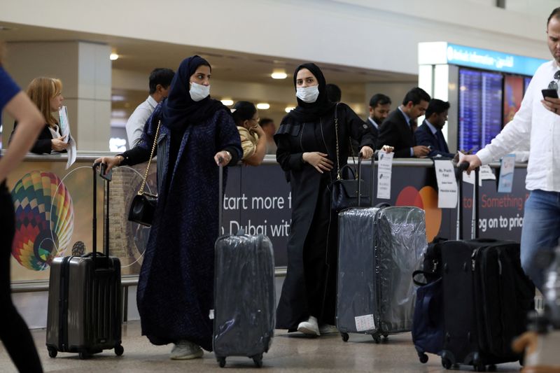 © Reuters. مسافرتان تضعان كمامتين في مطار دبي الدولي بصورة من أرشيف رويترز.