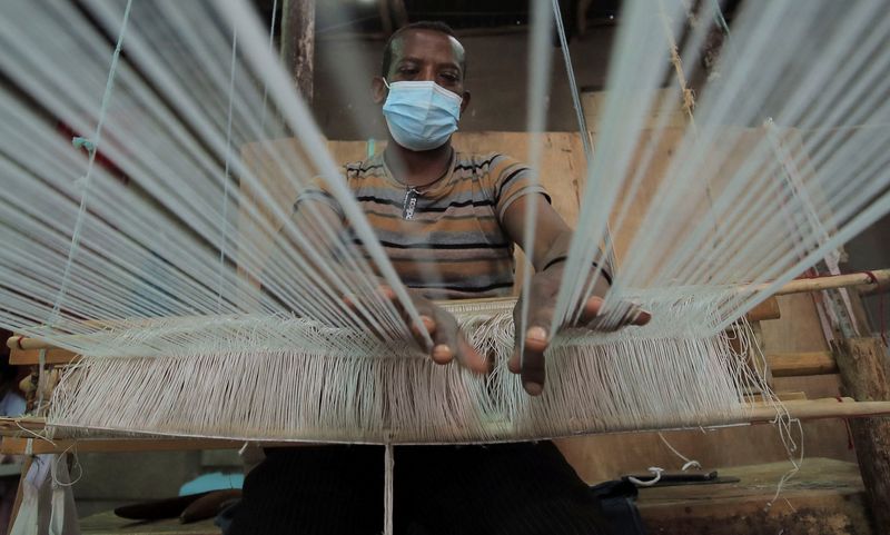 © Reuters. FILE PHOTO: Tadele Abate, 37, weaves a fabric at the Sammy Ethiopia hand made garments, hand-woven textiles and basketry factory in Addis Ababa, Ethiopia, October 14, 2021. REUTERS/Tiksa Negeri