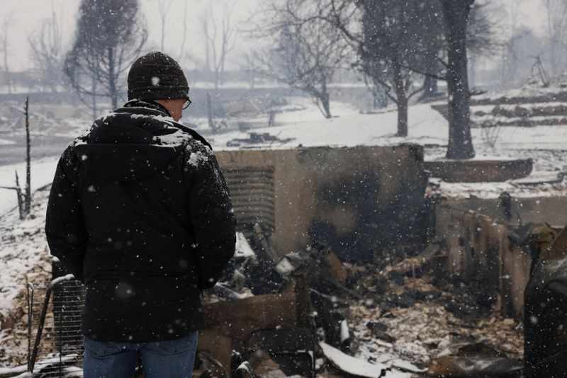 &copy; Reuters. شخص ينظر إلى أحد المنازل المحترقة في لويزيفل يوم 31 ديسمبر كانون الأول 2021. تصوير: كيفن موهات - رويترز