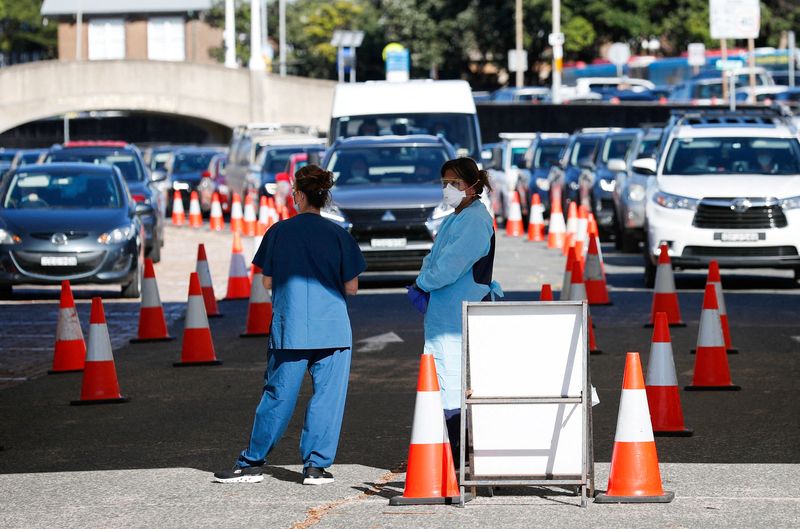 &copy; Reuters. FILE PHOTO: Healthcare workers wait for the next vehicle at a coronavirus disease (COVID-19) testing clinic as the Omicron coronavirus variant continues to spread in Sydney, Australia, December 30, 2021. REUTERS/Nikki Short