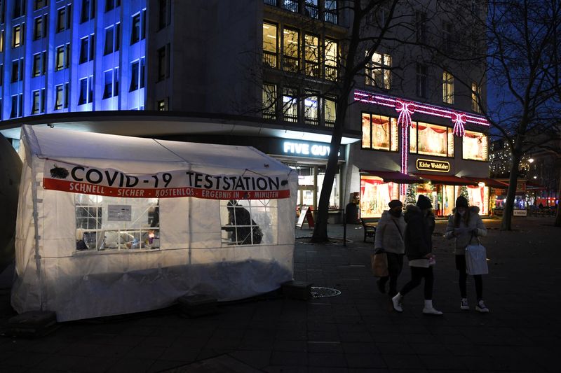 &copy; Reuters. FILE PHOTO: People walk by a COVID-19 testing station on the shopping street Kurfuerstendamm, amid the coronavirus disease (COVID-19) pandemic, in Berlin, Germany, December 1, 2021. REUTERS/Annegret Hilse