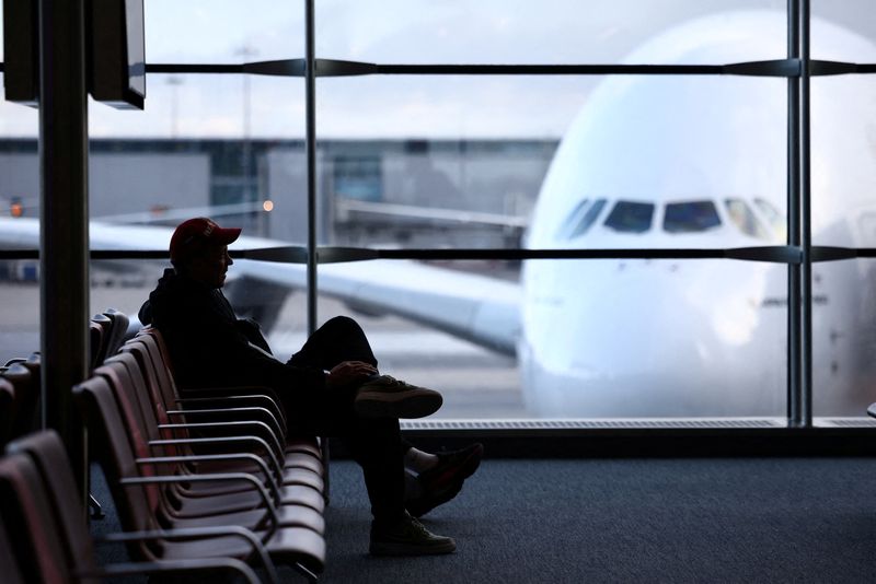 &copy; Reuters. 　ク新型コロナウイルス感染拡大による空の交通の混乱は新年になっても続き、２日は世界で４０００便以上が運休となった。写真はパリのシャルル・ドゴール空港でフライトを待つ男性。
