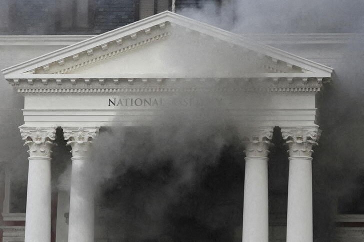 &copy; Reuters. دخان يتصاعد بعد اندلاع حريق بمبنى البرلمان في كيب تاون بجنوب أفريقيا يوم الأحد. تصوير: سمية هشام - رويترز.