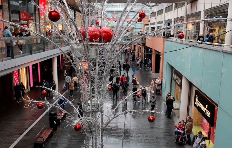 &copy; Reuters. FILE PHOTO: People carry shopping bags as they look for bargains in the traditional Boxing Day sales in Liverpool, Britain, December 26 , 2021. REUTERS/Phil Noble