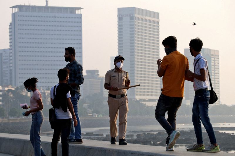 &copy; Reuters. A policeman asks people to leave the promenade at Marine drive, during restrictions to limit public gatherings amidst the spread of the coronavirus disease (COVID-19), in Mumbai, India, January 3, 2022. REUTERS/Niharika Kulkarni