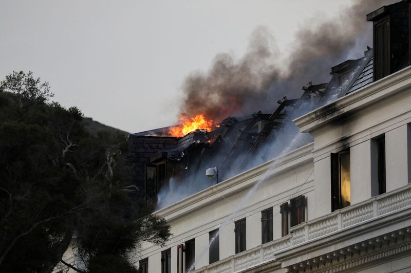 &copy; Reuters. نيران ودخان يتصاعدان من السقف مع نشوب حريق في برلمان جنوب أفريقيا مرة أخرى في كيب تاون يوم الاثنين. تصوير: سمية هشام - رويترز