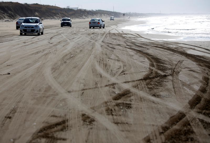 &copy; Reuters. FILE PHOTO: Cars drive along Chirihama Nagisa Driveway, the only place in Japan where cars can be driven by the edge of the surf, in Hakui, Ishikawa Prefecture, Japan December 3, 2017.  REUTERS/Issei Kato