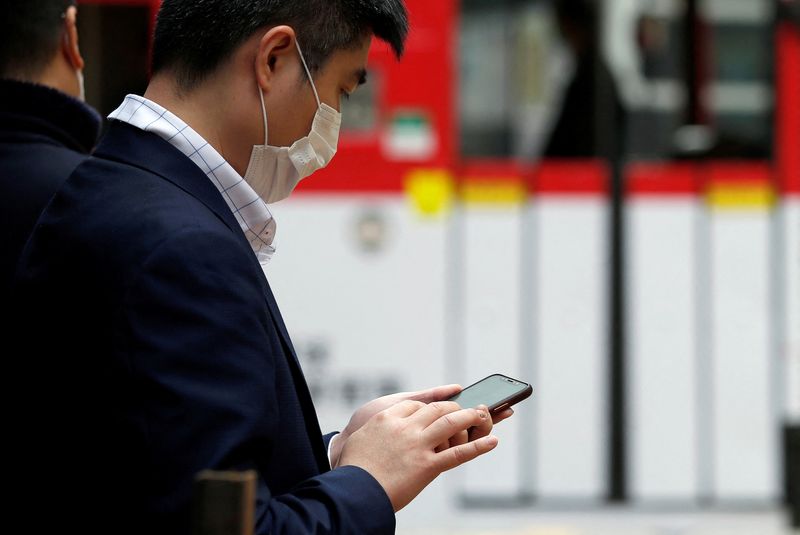 &copy; Reuters. FOTO DE ARCHIVO: Un hombre mira su teléfono móvil en Hong Kong, China 10 de febrero de 2020. REUTERS/Tyrone Siu 