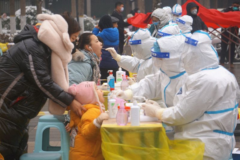 &copy; Reuters. Medical workers in protective suits collect swabs from residents during a citywide nucleic acid testing following cases of the coronavirus disease (COVID-19) in Zhengzhou, Henan province, China, January 5, 2022. cnsphoto via REUTERS  