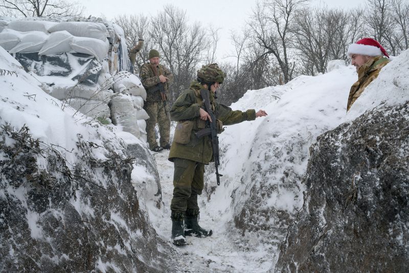 &copy; Reuters. FILE PHOTO: Service members of the Ukrainian armed forces gather in a trench at combat positions near the line of separation from Russian-backed rebels outside Krymske in the Luhansk region, Ukraine, January 3, 2022. REUTERS/Maksim Levin