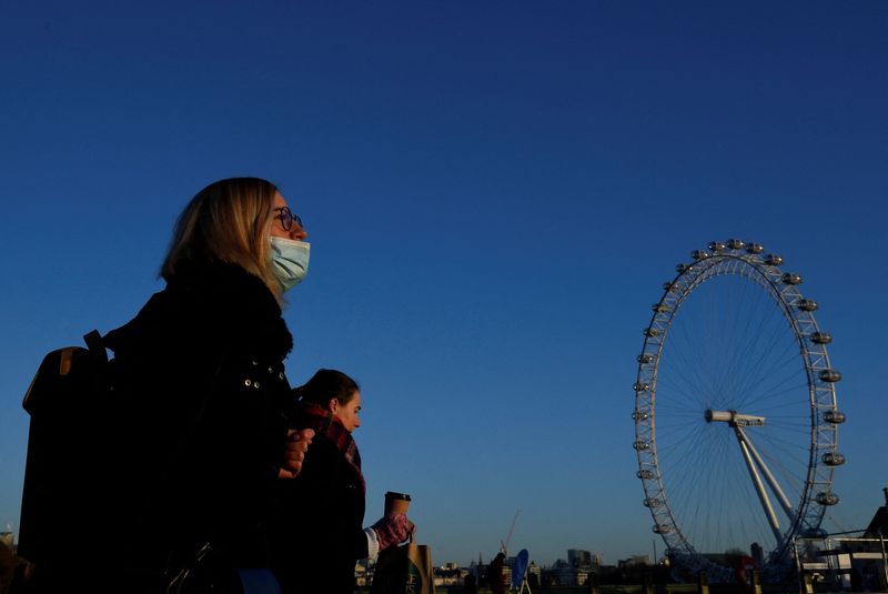 &copy; Reuters. A woman wearing a face mask crosses Westminster Bridge, with the London Eye wheel seen behind, during the morning rushhour, in London, Britain, January 5, 2022. REUTERS/Toby Melville