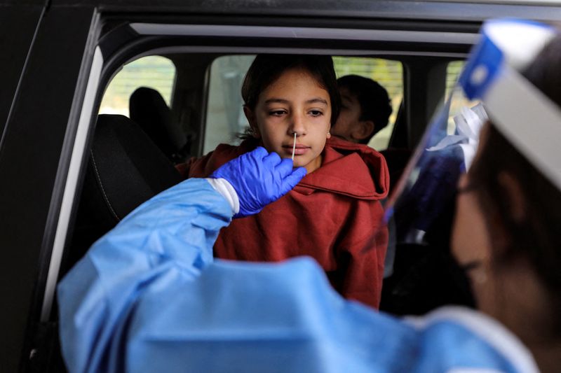&copy; Reuters. A girl is tested for the coronavirus disease (COVID-19) at a drive-through site as Israel faces a surge in Omicron variant infections in Jerusalem January 3, 2022. REUTERS/Ammar Awad