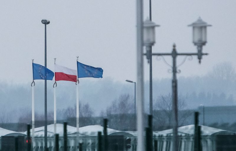 &copy; Reuters. Una vista desde el lado bielorruso de la frontera muestra banderas polacas y de la UE trás una valla en el puesto de control de Bruzgi-Kuznica en la frontera bielorrusa-polaca durante la crisis de los migrantes en la región de Grodno, Bielorrusia, 23 de