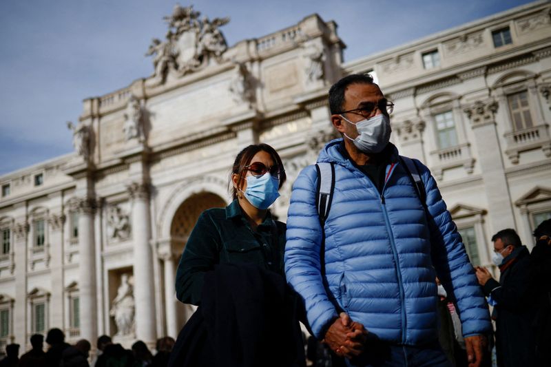 &copy; Reuters. Pessoas usando máscara de proteção passam em frente à Fontana de Trevi em Roma
30/12/2021 REUTERS/Guglielmo Mangiapane