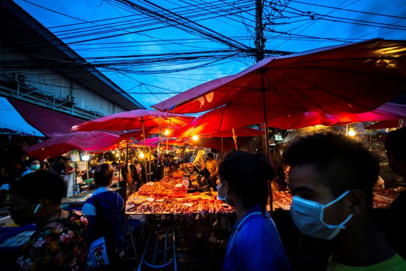 &copy; Reuters. 　１月６日、タイは、新型コロナウイルスのオミクロン変異株を中心とした感染者急増を受け、警戒レベルをこれまでの「３」から「４」に引き上げた。写真はタイのバンコクの市場で昨年