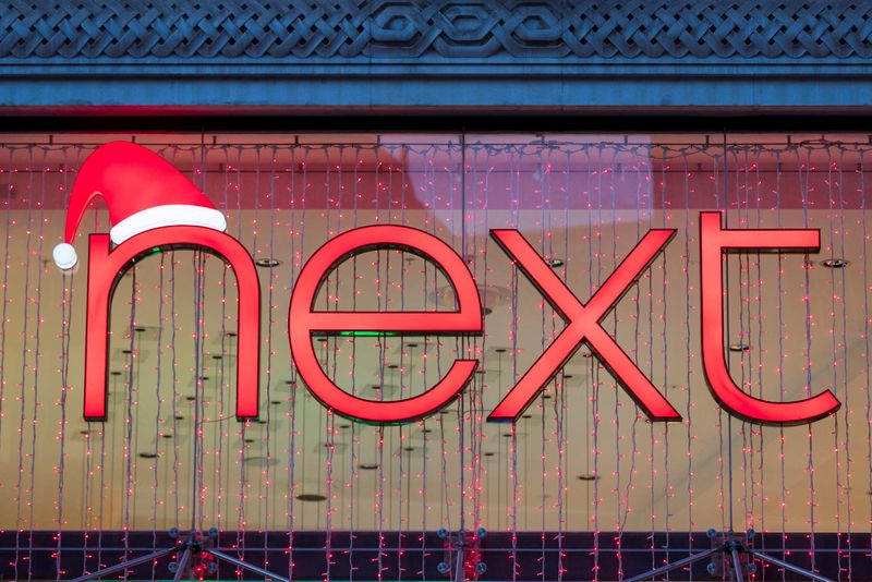 © Reuters. FILE PHOTO: A Christmas themed logo of clothing retailer Next is seen at a store in London, Britain, December 2, 2021. REUTERS/May James