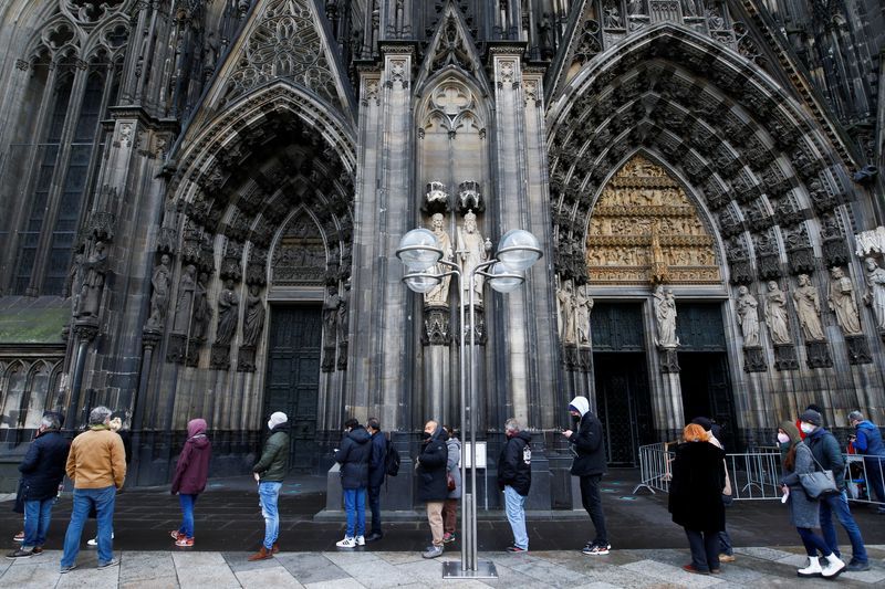 &copy; Reuters. FILE PHOTO: People queue to receive a dose of the Pfizer-BioNTech COVID-19 vaccine during a vaccination event in the Cologne Cathedral on Christmas Eve amid the coronavirus disease (COVID-19) pandemic in Cologne, Germany, December 24, 2021. REUTERS/Thilo 