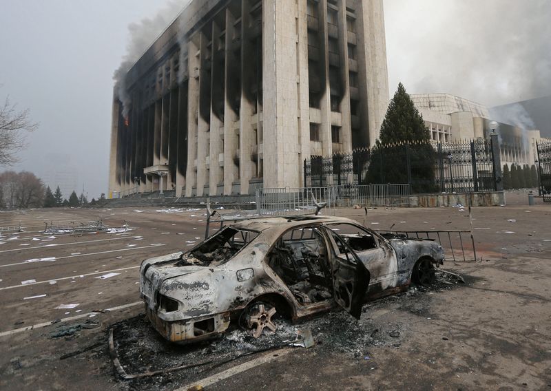 © Reuters. A burned car is seen in front of the mayor's office building which was torched during protests triggered by fuel price increase in Almaty, Kazakhstan January 6, 2022. REUTERS/Pavel Mikheyev