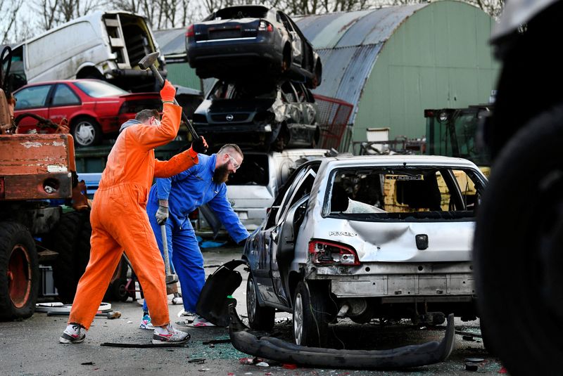 &copy; Reuters. Twin brothers Steven and Brian Krijger use hammers to scrap a car to express their frustration as the Netherlands undergoes another lockdown in Vijfhuizen, Netherlands January 5, 2022.  REUTERS/Piroschka van de Wouw