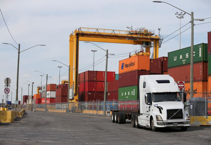 © Reuters. FILE PHOTO: A truck moves past stacked shipping containers at the Port of Montreal in Montreal, Quebec, Canada, May 17, 2021.  REUTERS/Christinne Muschi/File Photo