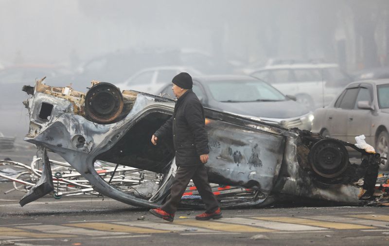 &copy; Reuters. A man walks past a car that was burned during the protests triggered by fuel price increase in Almaty, Kazakhstan January 6, 2022. REUTERS/Pavel Mikheyev