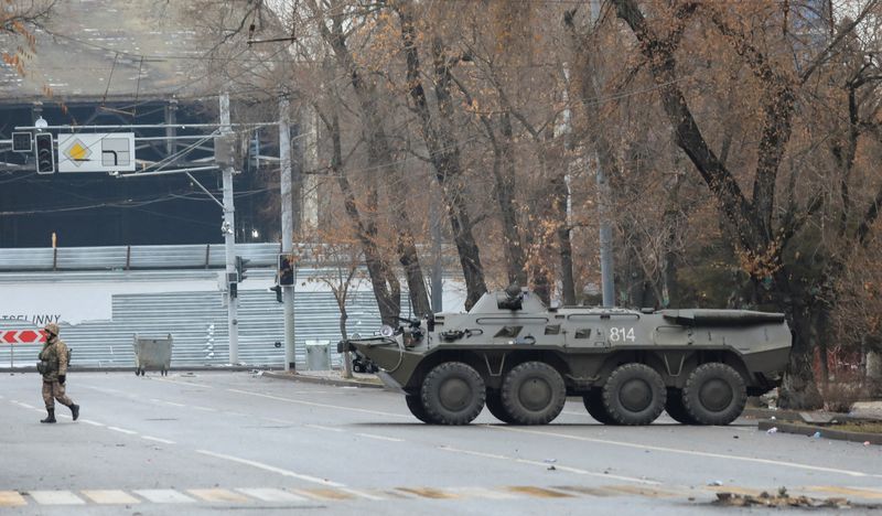 © Reuters. A Kazakh service member walks near an armoured personnel carrier following the protests triggered by fuel price increase in Almaty, Kazakhstan January 7, 2022. REUTERS/Pavel Mikheyev