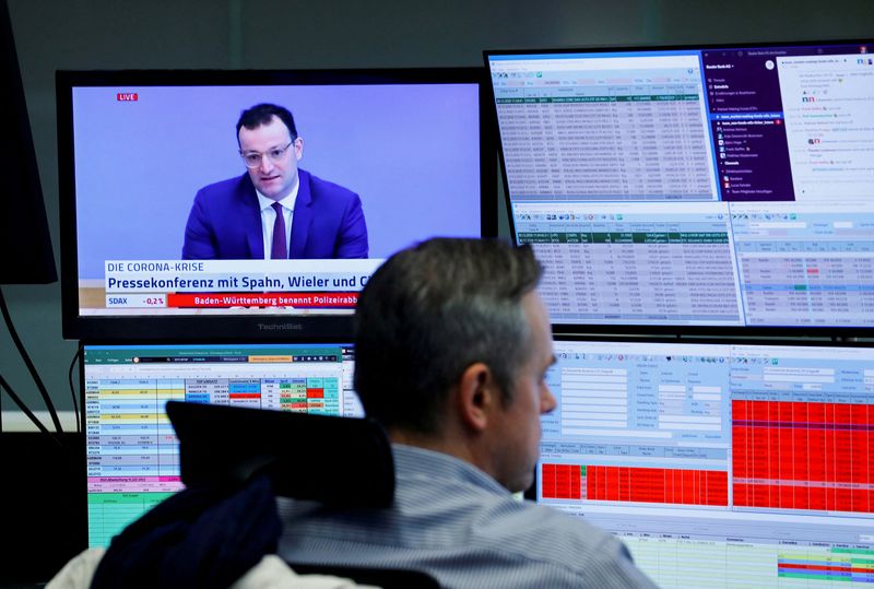 &copy; Reuters. FILE PHOTO: A trader sits in front of a television broadcast showing German Health Minister Jens Spahn during a trading session at the Frankfurt's stock exchange, amid the coronavirus disease (COVID-19) outbreak, in Frankfurt, Germany, December 30, 2020. 