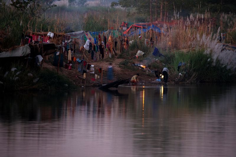 &copy; Reuters. Refugees, who have fled a flare-up in fighting between the Myanmar army and insurgent groups and settled temporarily on the Moei River Bank, are seen on the Thai-Myanmar border, in Mae Sot, Thailand, January 7, 2022. REUTERS/Athit Perawongmetha