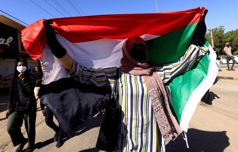 &copy; Reuters. متظاهر يرفع علم السودان أثناء مسيرة متظاهرين ضد الحكم العسكري في الخرطوم في السادس من يناير كانون الثاني 2022. تصوير: محمد نور الدين - رويترز. 