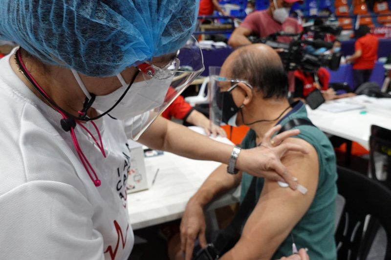 &copy; Reuters. رجل يتلقى لقاحا للوقاية من فيروس كورونا في مركز تطعيم في سان خوان في الفلبين يوم 29 نوفمبر تشرين الثاني 2021. تصوير: بيتر بلازا - رويترز.