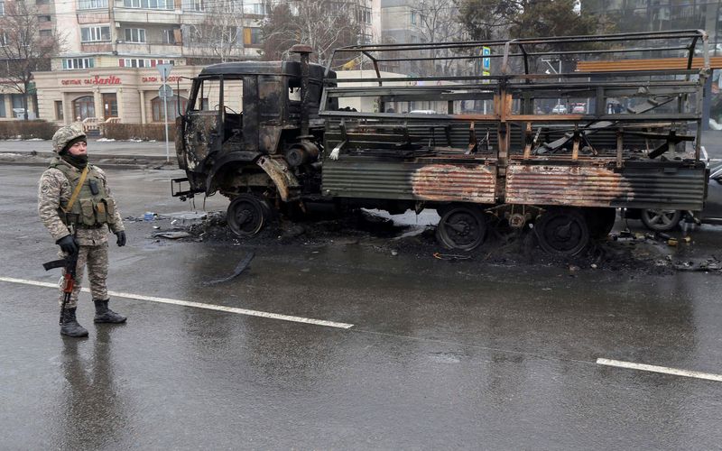 &copy; Reuters. Un agente policial kazado hace guardia cerca de un camión quemado, mientras revisa vehículos en una calle después de disturbios masivos provocados por un aumento de los precios del combustible Almaty, Kazajistán. 8 de enero, 2022. REUTERS/Pavel Mikhey
