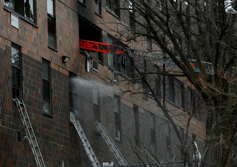© Reuters. أفراد من قوات الطوارئ خلال اطفاء حريق بمبنى سكني في حي برونكس بمدينة نيويورك يوم الأحد. تصوير:رويترز.