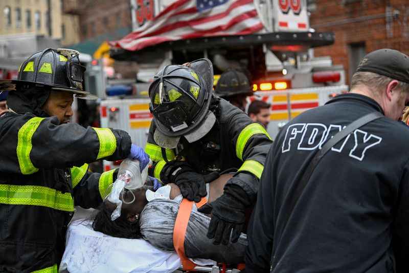 &copy; Reuters. Personal de emergencias de Deparmento de Bomberos de Nueva York brinda asistencia médica mientras responder a un incendio en un edificio de departamentos en el distrito del Bronx de la Ciudad de Nueva York, Nueva York, Estados Unidos. 9 de enero, 2022.  
